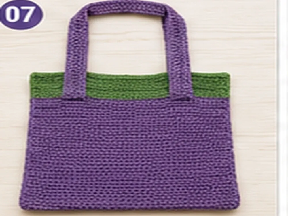 Purple crochet handles attached to the green and purple tote body
